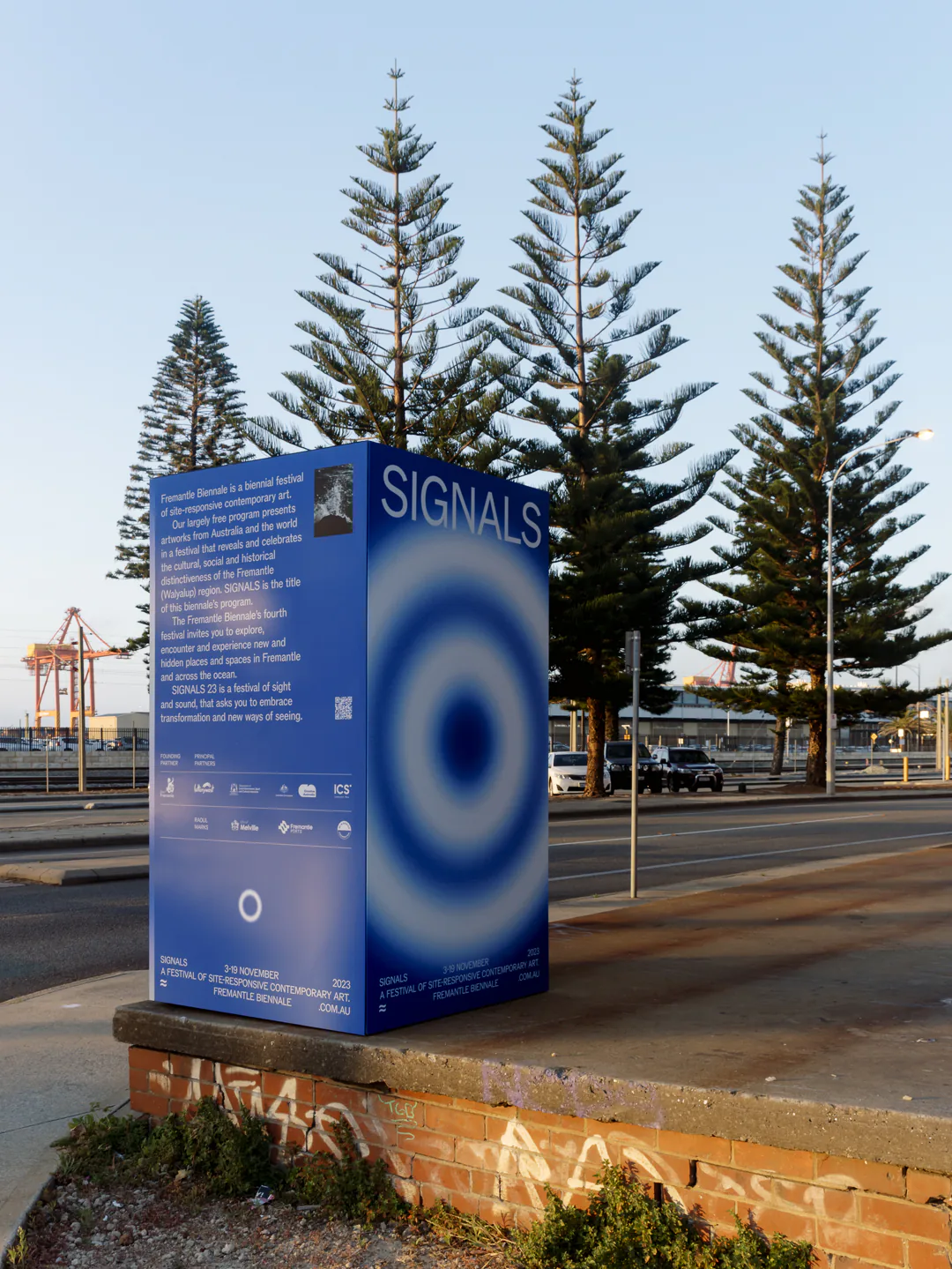Blue Signals monolith beside Norfolk Island pines at Fremantle port