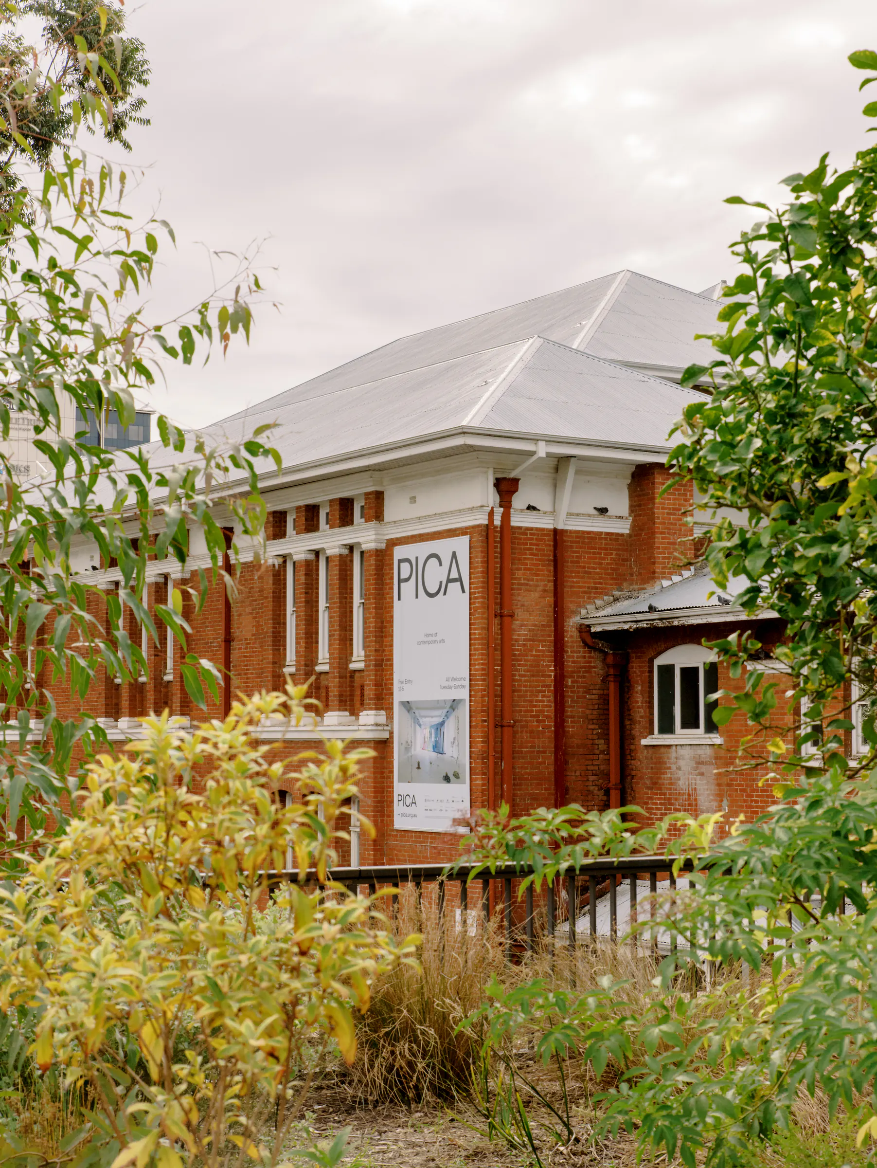 PICA gallery identity and programme banner seen through the surrounding garden