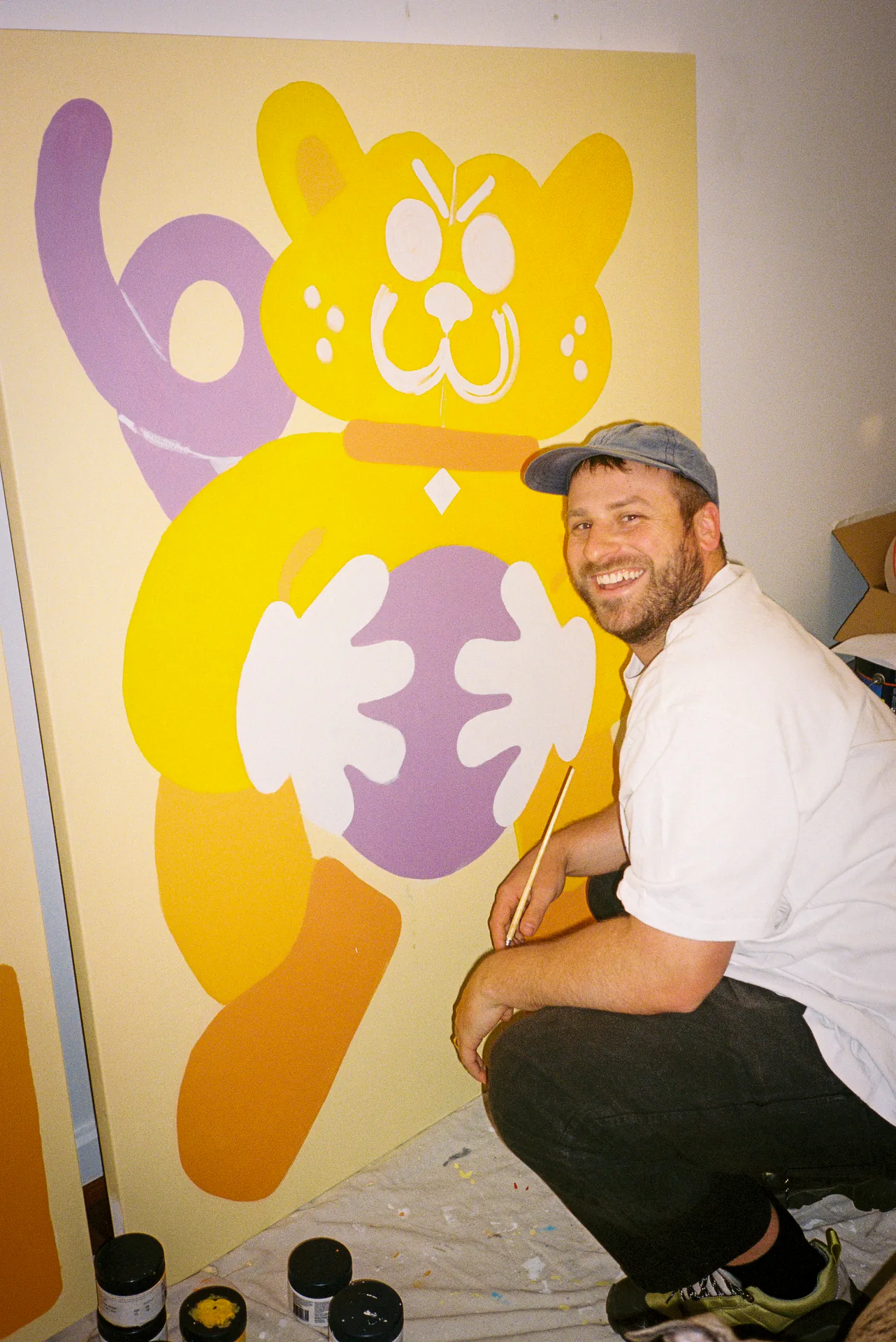 An artist working on the yellow Sports Dreams character painting