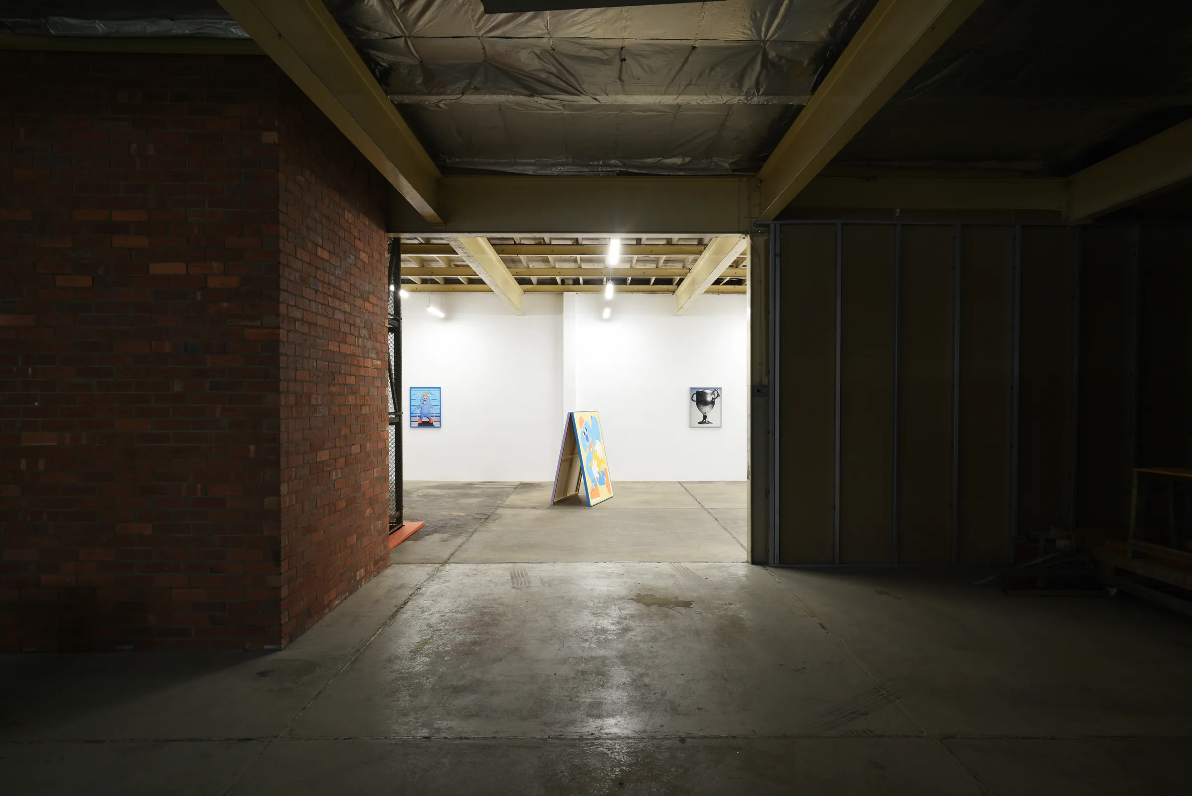 View from the dark entrance into the brightly lit Sports Dreams exhibition