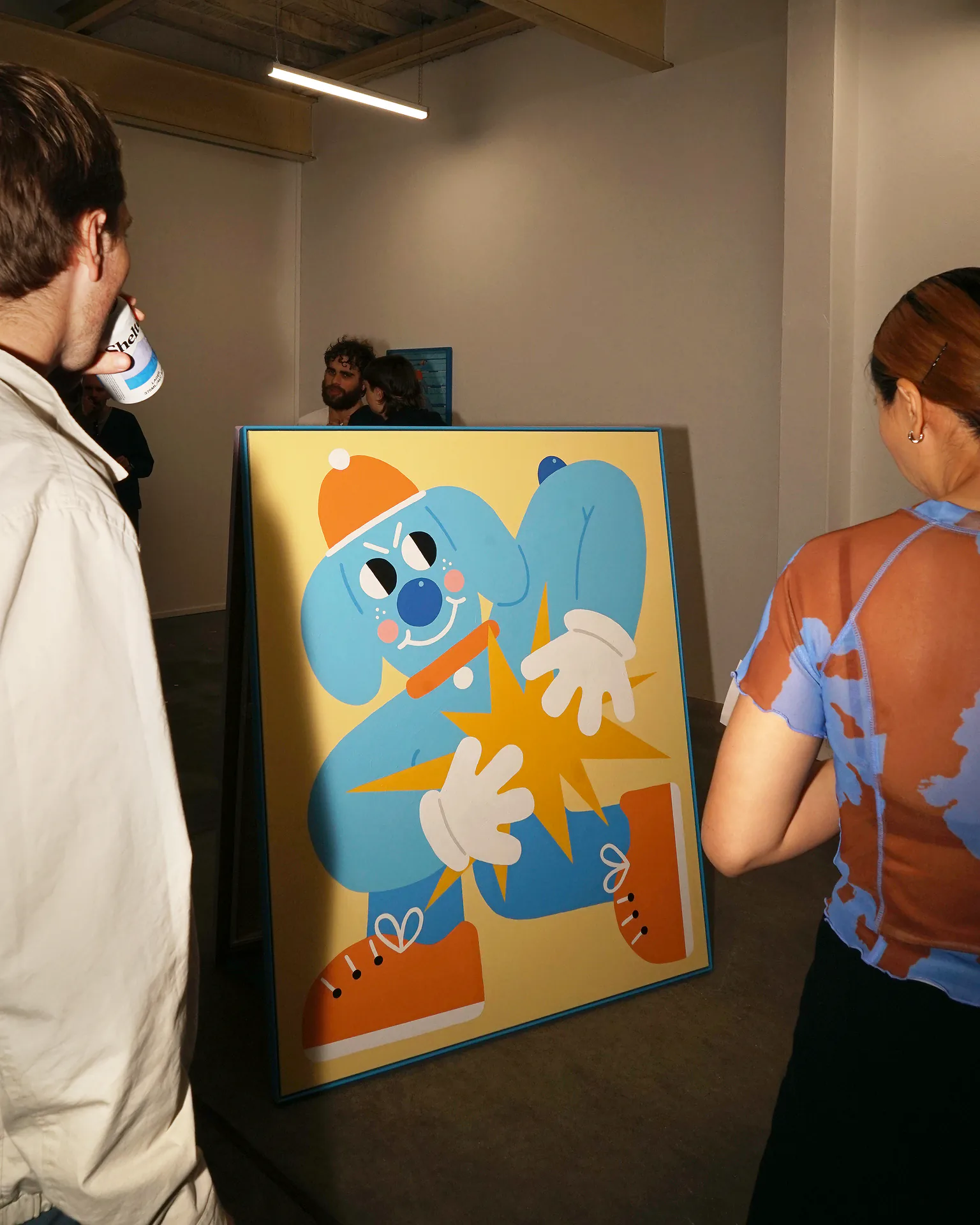Opening-night visitors gathered beside the blue Sports Dreams painting