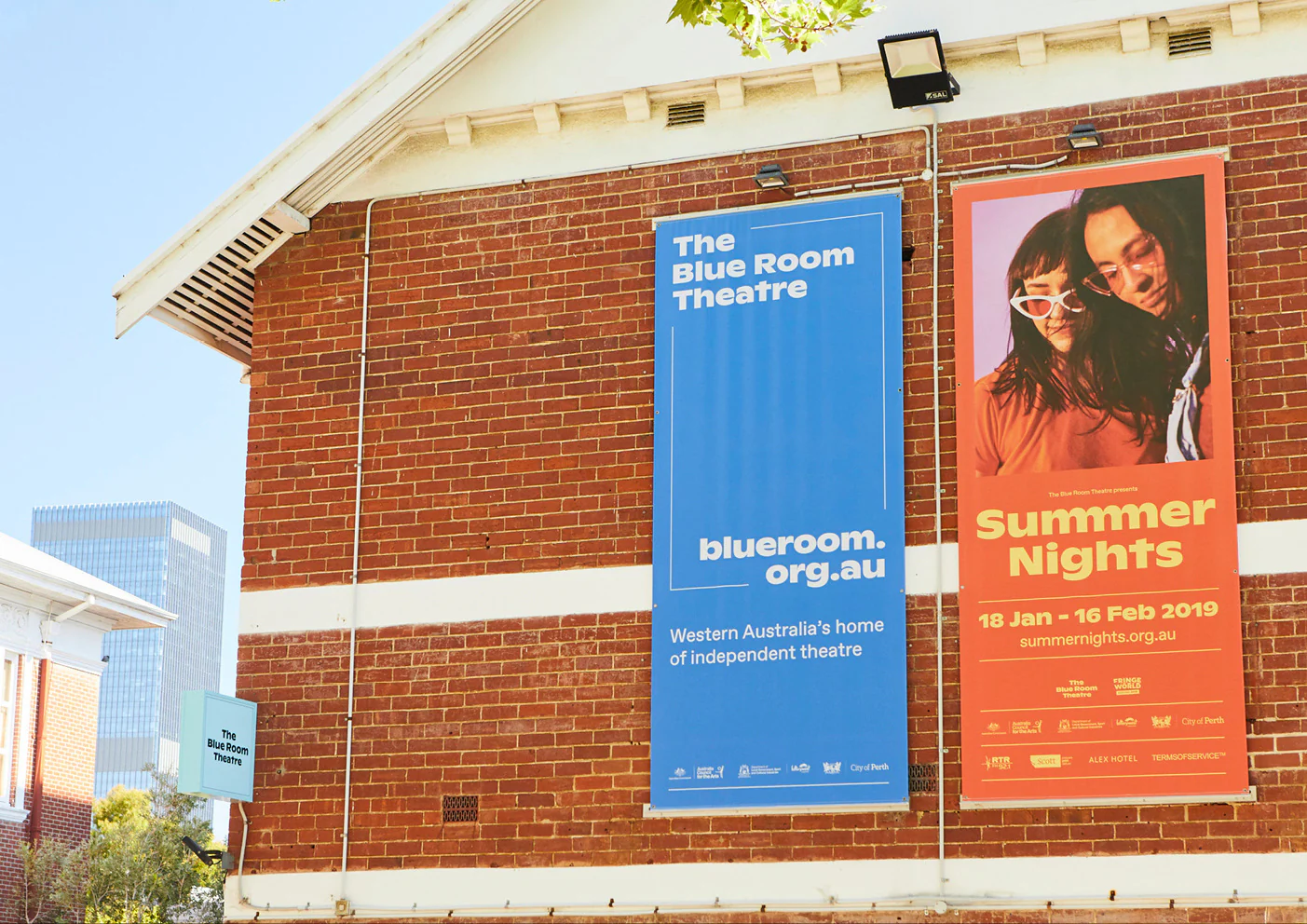 The Blue Room Theatre and Summer Nights banners on the theatre’s brick facade